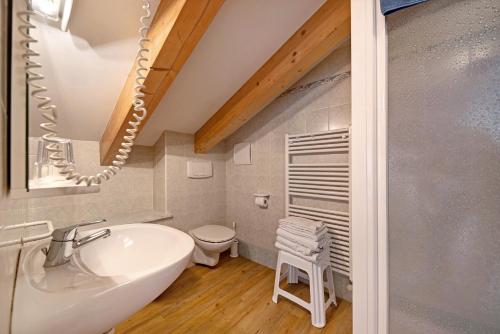 a bathroom with a white sink and a toilet at Residence Montebel Studio in Tesero
