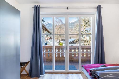 a bedroom with a large window with a view of mountains at Beim Klarwein in Farchant