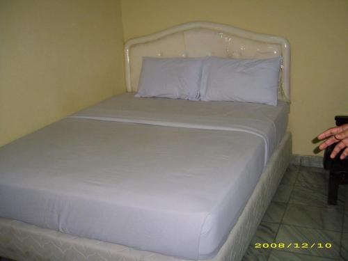 a white bed in a room with at Hotel Pinangsia in Jakarta