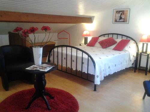 a bedroom with a bed and a chair and a table at Villa Gastandeia in Cambo-les-Bains