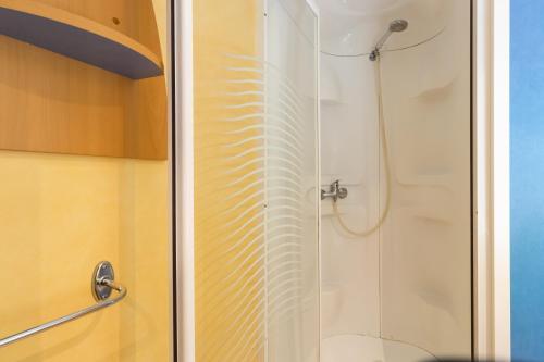 a shower with a glass door in a bathroom at Mobilhome La Clairière in Saint-Pompont