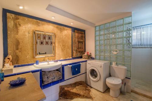 a bathroom with a toilet sink and a washing machine at Maison Mer Peniscola in Peniscola