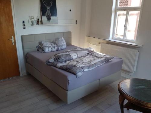 a bedroom with a bed and a table and a window at Ferienwohnung Pfieffetalblick in Spangenberg