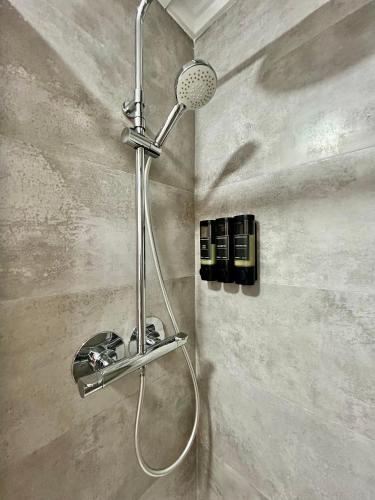 a shower with a shower head in a bathroom at Sueña Mar Luxury Suites in Torrevieja