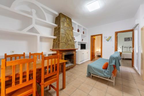 a living room with a dining table and a fireplace at Villa Loli 2 in El Pozo de los Frailes