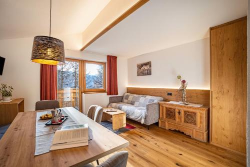 a living room with a table and a couch at App Hubertus - Wasserfallspitz in Sand in Taufers