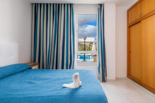 a room with a bed with a white animal on it at Apartamento Via Alemanya in Can Picafort