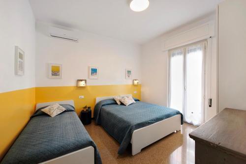 a bedroom with two beds and a window at Il ciliegio di Miki in Genoa