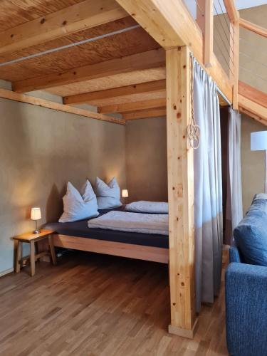 a bedroom with a bed under a wooden ceiling at bund Ferienwohnung in Lenzen