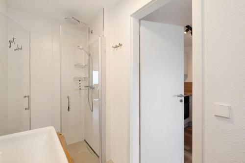 a white bathroom with a shower and a sink at Ferienwohnung Luftige Auszeit in Bühlertal