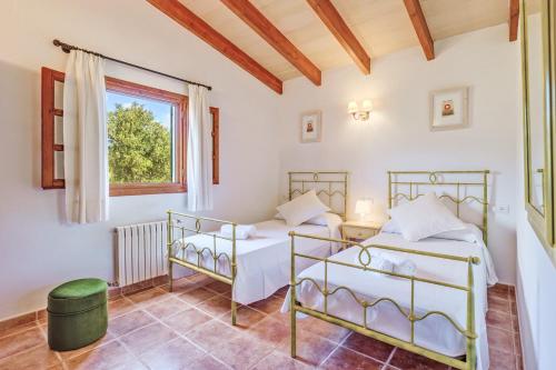 a bedroom with two beds and a window at Villa Joana in Pollença