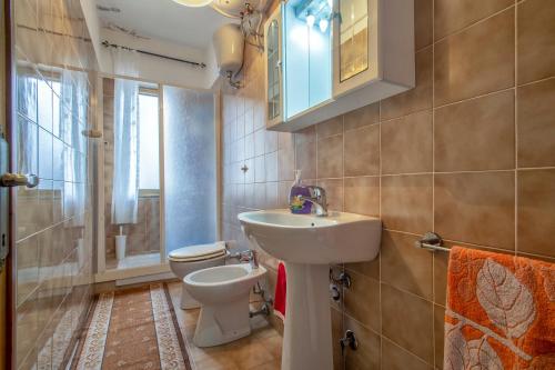 a bathroom with a sink and a toilet at Veranda Vista Mare Isola Rossa in Isola Rossa