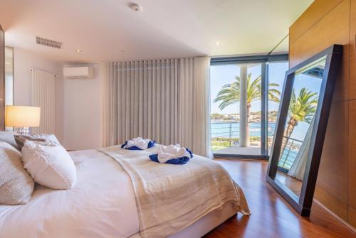 a bedroom with a bed with a view of the ocean at Sa Bateria in Portocolom