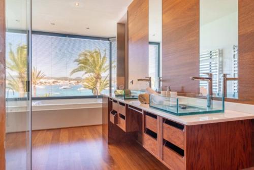 a bathroom with two sinks and a large window at Sa Bateria in Portocolom