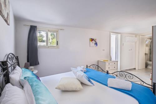 a bedroom with a bed with blue and white pillows at Elenya Garden Retreat in Torre Lapillo