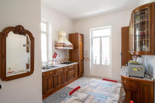 a kitchen with wooden cabinets and a sink and a mirror at Villa Verde - 300m From Sea in Bordighera