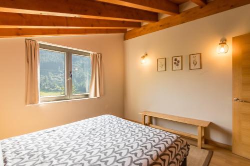 a bedroom with a bed and a window at La Riega Del Peral in Ojedo