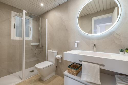 ein Badezimmer mit Waschbecken, Toilette und Spiegel in der Unterkunft Las Conchas in Cunit