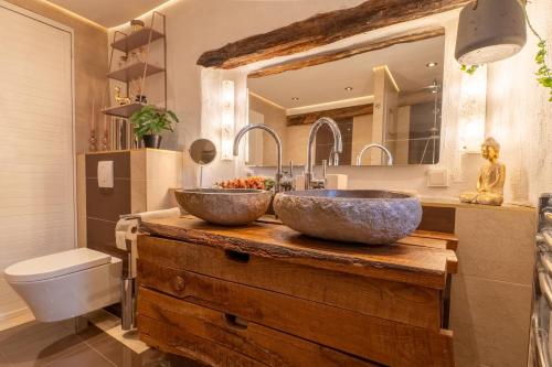 two sinks on a wooden counter in a bathroom at Kleines Eifel Backhaus mit Sauna in Feuerscheid