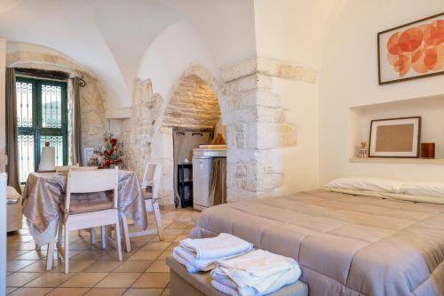 a bedroom with a bed and a table in a room at Dimora La Piana in Ostuni