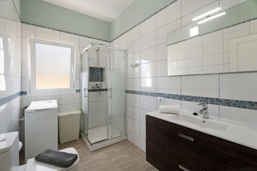 a white bathroom with a sink and a shower at Casa Elvira in Frontera