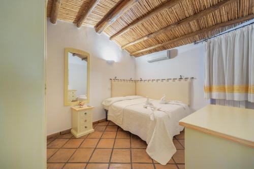 a bedroom with a bed and a mirror at Villa Roccia in Porto Rotondo