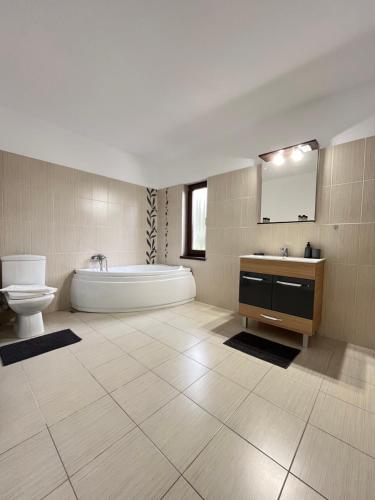 a bathroom with a tub and a toilet and a sink at Casa Liniștea Pădurii in Gura Văii
