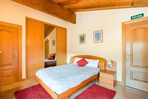 a bedroom with a bed with a red rug at Juanikoenea in Leitza