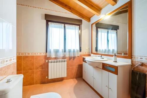 a bathroom with a toilet sink and a mirror at Juanikoenea in Leitza