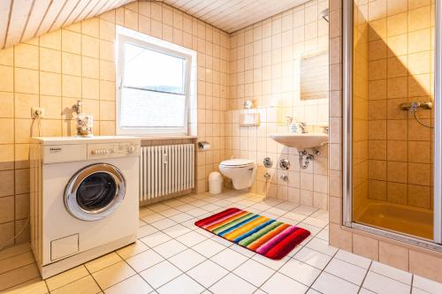 a bathroom with a washing machine and a sink at Jonagold in Stockach