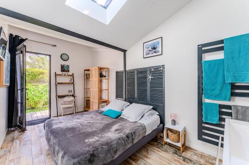 a bedroom with a bed and a window at La Villa Sanson in Arcachon