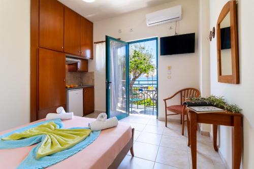 a bedroom with a bed and a table and a kitchen at Nikiana Club - Studio 4 in Nikiana