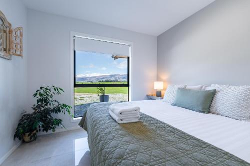 a bedroom with a large bed with a large window at 2BR Guest Retreat in Country Home with Shared Hallway in Tarras