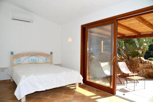 a bedroom with a bed and a sliding glass door at Villa Ibiscus in Porto Rafael