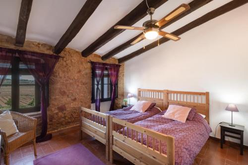 a bedroom with a bed and a ceiling fan at Les Orenetes casa rural in Sant Jaume dels Domenys