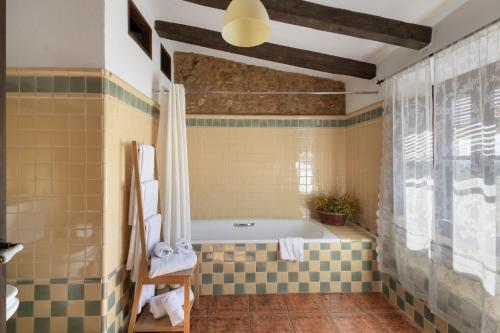 a bathroom with a bath tub and a window at Les Orenetes casa rural in Sant Jaume dels Domenys