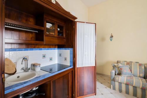 a bathroom with a sink and a couch at Mono Scilla Centro Storico Otranto in Otranto