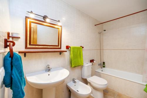 a bathroom with a sink and a toilet and a mirror at Casa Frank in Conil de la Frontera