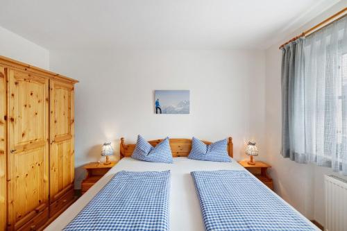 a bedroom with a bed with blue and white pillows at Fewo Brünnstein - Nr 28 Pool, Sauna in Oberaudorf