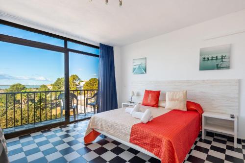 a bedroom with a bed and a large window at Estudio Mirada 304 in Es Pujols