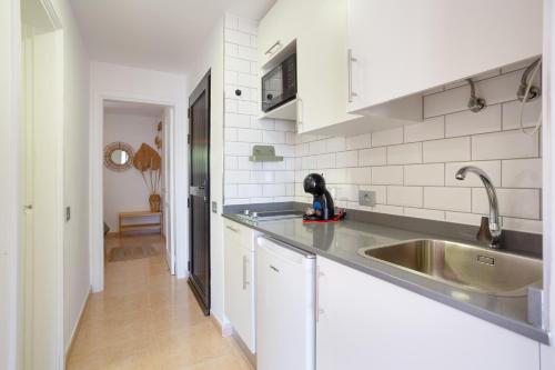 a kitchen with a sink and a counter top at Oasis Duna-Pistacho dreams Pool in Corralejo