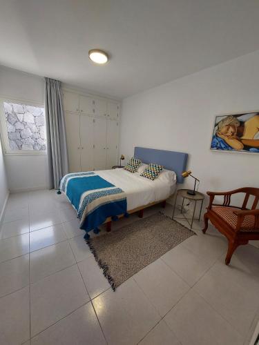 a bedroom with a bed and a chair in it at Casa Guayo in Tías