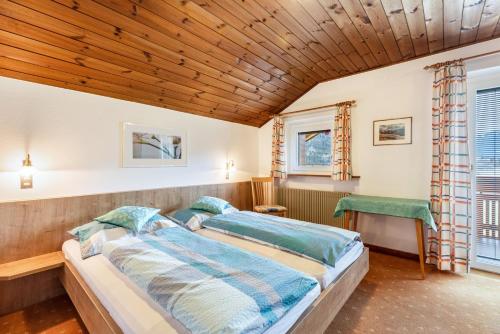 a bedroom with a bed and a wooden ceiling at Unterhauserhof App C in Valdaora