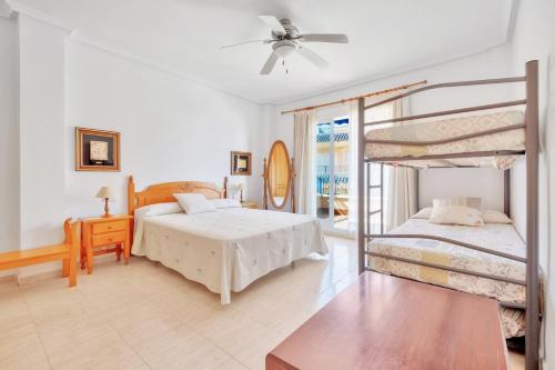 a bedroom with two bunk beds and a balcony at Casa en playa con piscina Novamar in Santa Pola