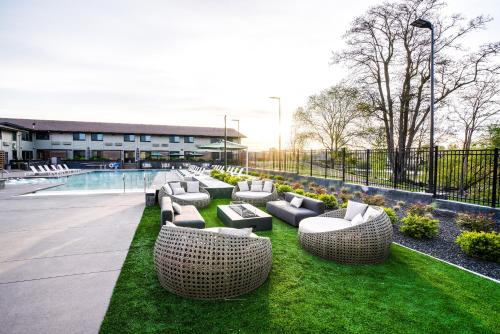 a row of couches sitting on the grass near a pool at Ruby River Hotel in Spokane
