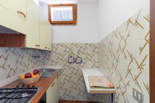 a kitchen with a sink and a bowl of fruit at Simona Panorama in Fetovaia