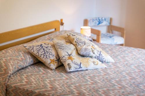 a group of pillows sitting on top of a bed at Simona Panorama in Fetovaia