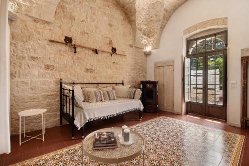 a bedroom with a bed and a brick wall at La Dimora dello Zio, with pool in Ostuni