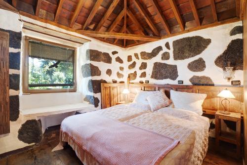 a bedroom with a bed in a room with a stone wall at Casa el Gordi in El Paso