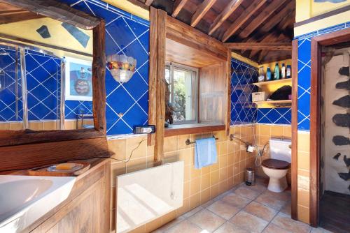 a bathroom with blue tiled walls and a toilet at Casa el Gordi in El Paso